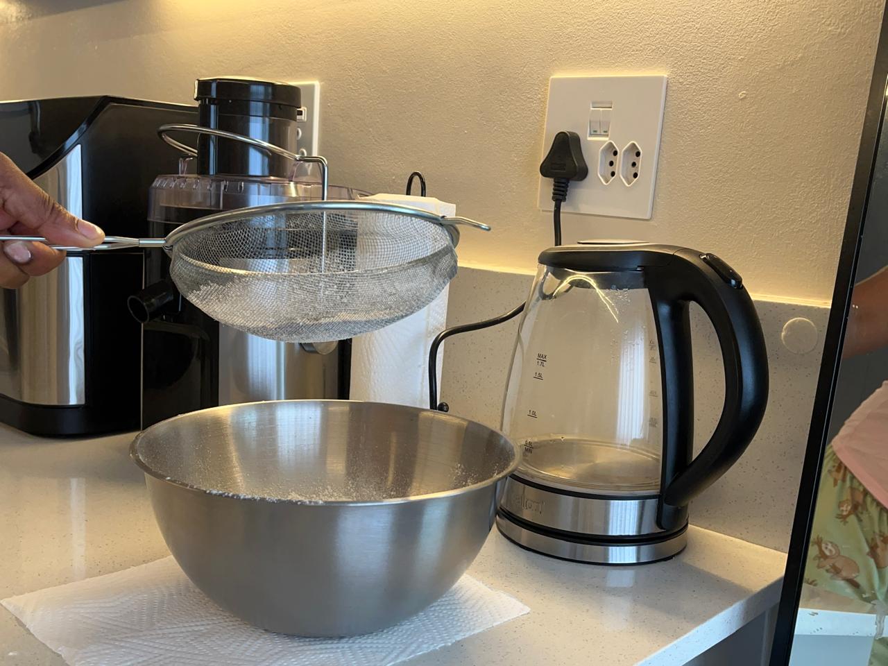 Sifting flour into a mixing bowl